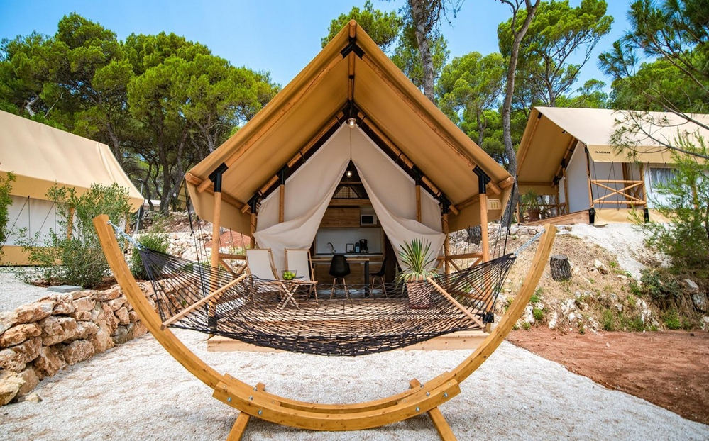 Falu végén kicsi kemping, mellette egy nagyobb glamping 4 glamping, sátor, lakókocsi