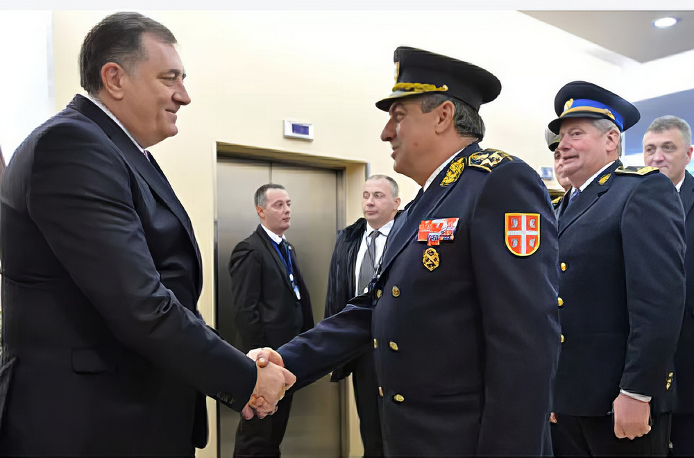 Milodar Dodik a boszniai Szerb Köztársaság elnöke egy 2017-es felvételen fogadja Ljubiša Ɖiković szerbiai vezérkeri főnököt a január 9-i ünnepségsorozaton a Drinán túlról, aki mögött akkor is ott sorakozott Gojko Knezević dandártábornok