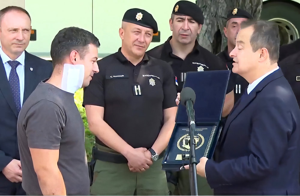 A szerb belügyminiszter bátorságért járó plakettel jutalmazta Miloš Jevremovićot, akit egy vahhábista az izraeli nagykövetség előtt nyílpuskával lőtt meg. A miniszter az ünnepségen azt is bejelentette, hogy sárgára csökkentik a terrorfenyegetettséget (Forrás: Screenshot, N1, Tanjug)