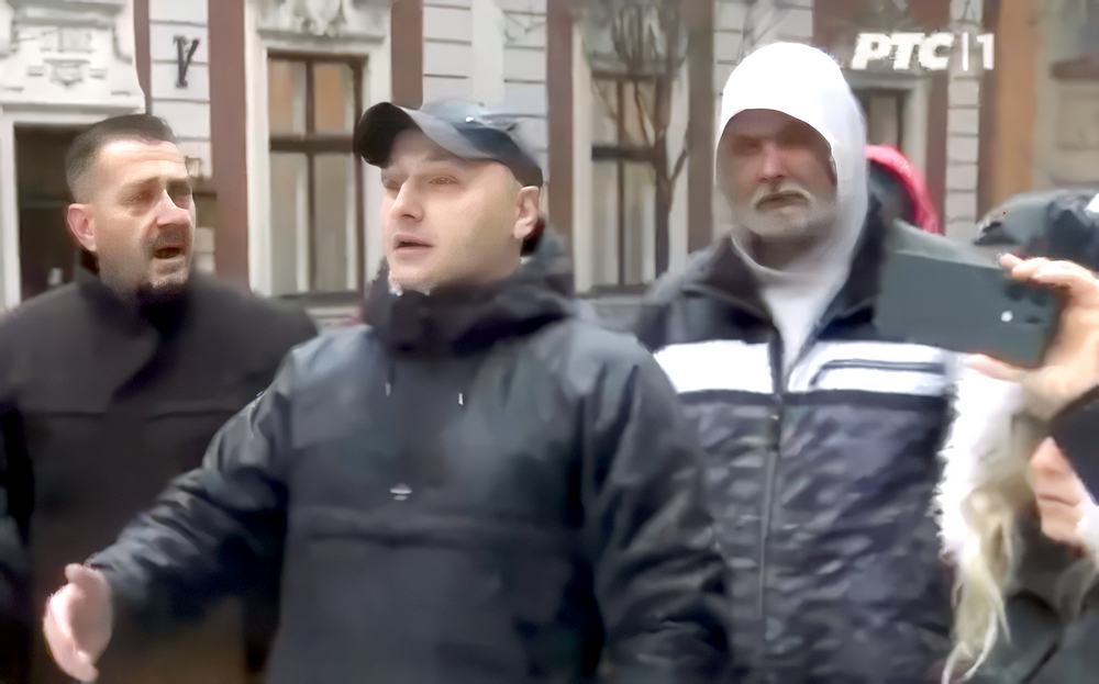 A haladók megzavarták a megemlékezéseket, sértegették és bántalmazták a visszaemlékezőket 4 A szerbiai állami televízió előtt is volt megemlékezés. A micis férfi egy haladó verőlegény, aki dühös, mert az autójával haladóként nem tud haladni