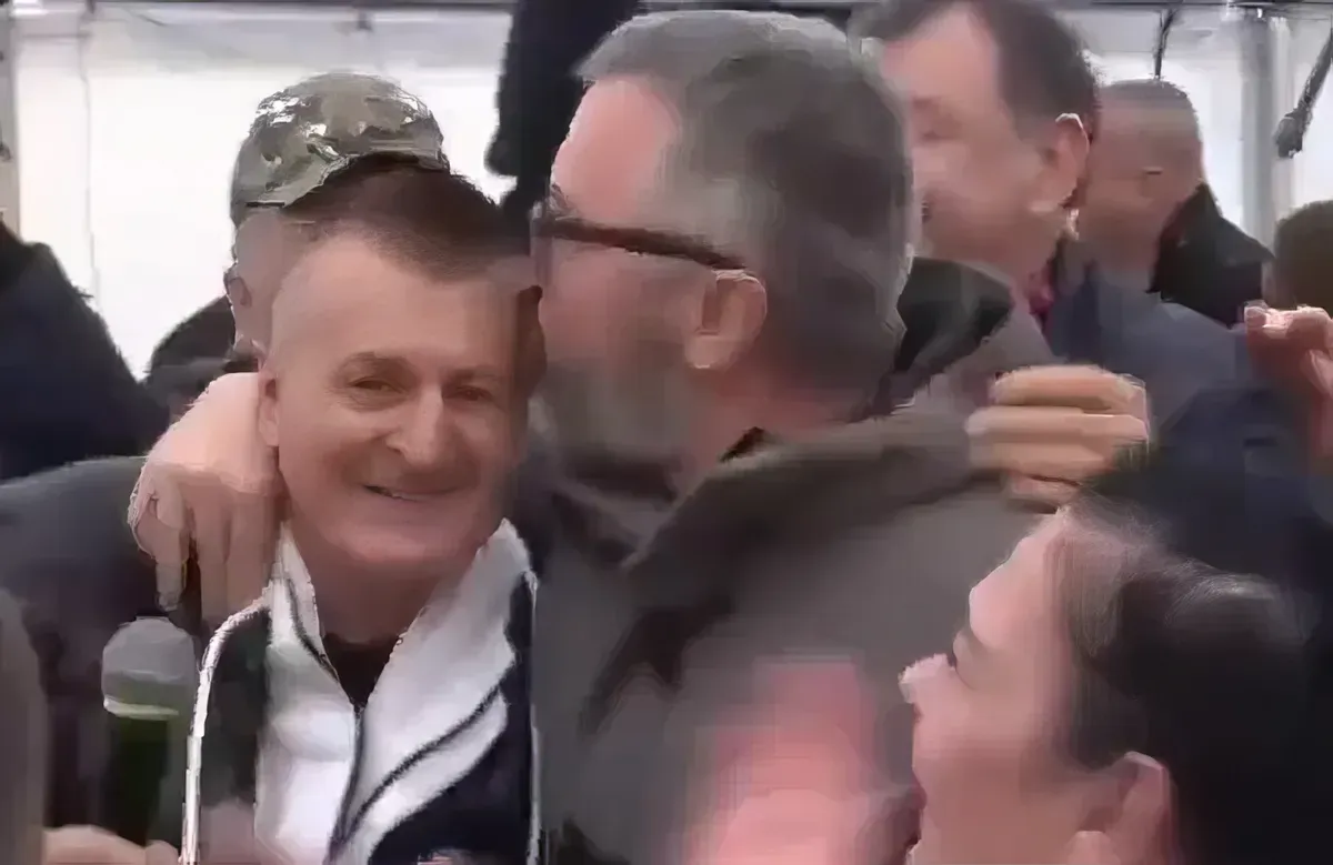 A féktelen öröm kifejeződési formája a férfias csók, amelyet a főszerkesztő nyom az énekes tarkójára