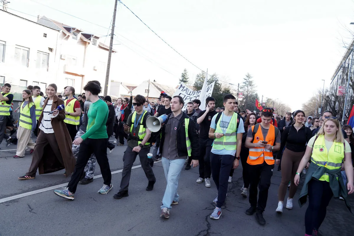 A szerb állami hírügynökség is beszámolt az egyetemisták meneteléséről. A Tanjug által készített fotónak két érdekessége van, az egyik, hogy az N1-es, nem éppen kormánybarát televízió riporternője is látható rajta, a másik pedig a kép bal felső sarkában feltűnő alak