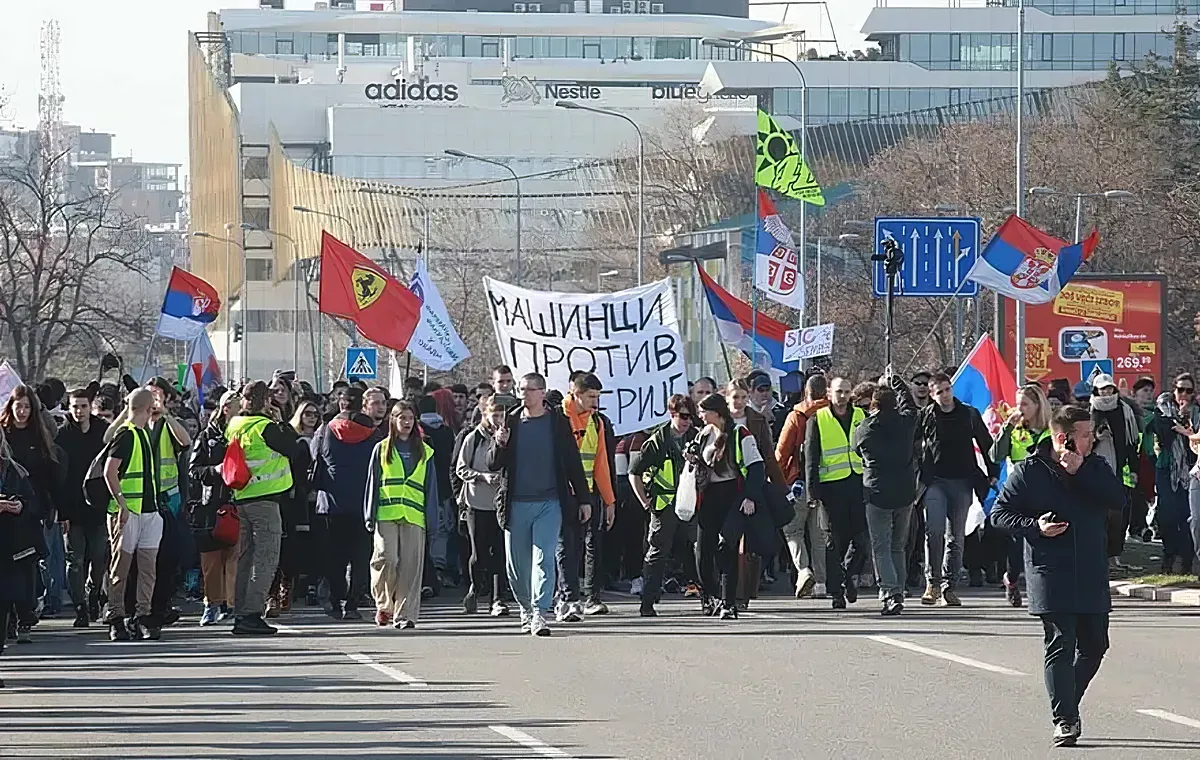 A belgrádi diákok Újvidékre mennek, a felvonulásokat általában a gépészek vezetik, őket könnyű felismerni a "Gépészek a gépezet ellen" feliratú transzparensükről. Ezúttal feltűnik a Ferrari-zászló is, amely az 1996-os nagy diáklázadásra emlékeztet. Az 1996-os és 1997-es nagy belgrádi diáktüntetéseken az egyetemisták hónapokon át tiltakoztak Slobodan Milošević rezsimje ellen