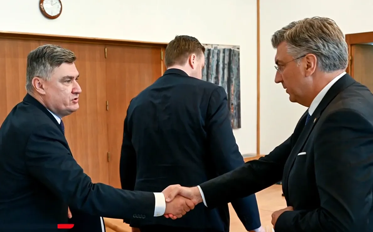 Kezet fogott a horvát elnök (balról) és a horvát miniszterelnök (jobbról). A Horvát Védelmi Tanács üléséről - amelyen találkoztak - televíziós felvétel nem készült