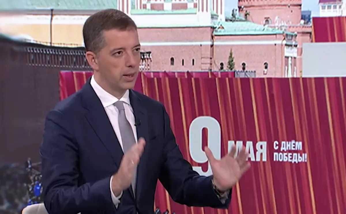 Marko Đurić szerb külügyminiszter az RTS közszolgálati televízióban, a háttérképen a moszkvai díszszemle mesterlövészekkel a tetőn