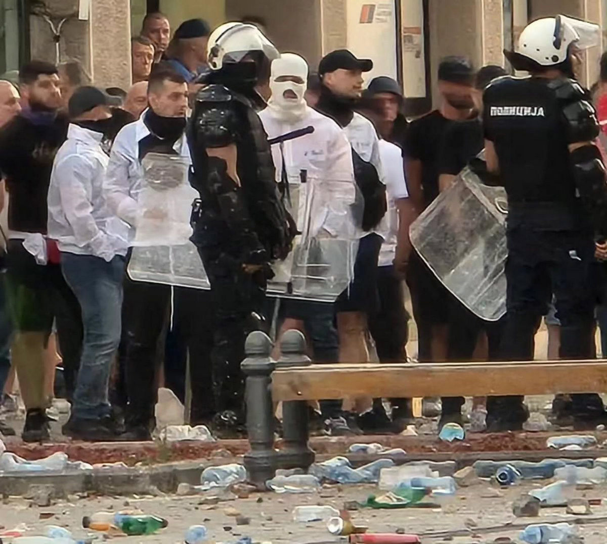 Verőlegények a Szerb Haladó Párt irodája előtt. Internetes források szerint reggel hat órakor újabb csoport érkezett, nem azért vitték oda őket, hogy összeszedjék a szétdobált PET-palackokat (üvegeket)
