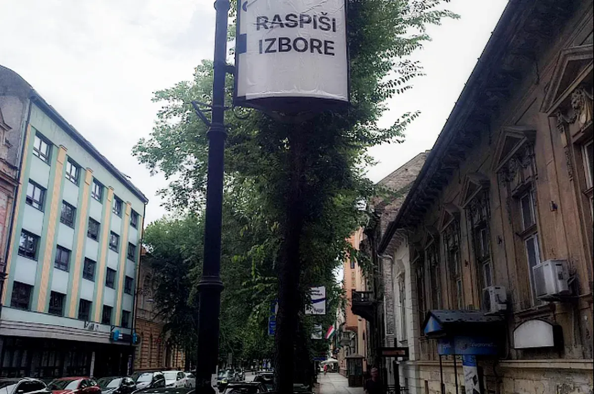 Vajdasági Magyar Plénum, Pásztor Bálint - Szabadkai városkép egy átragasztott plakáttal, amelyen az olvasható, hogy "írd ki a választásokat". A szerb elnök egy kijelentése szerint tisztogatásra készül a nagyobb városokban, és ezzel kapcsolatban alig félreérthetően Szabadkát is megemlítette
