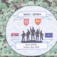 A NATO és Szerbia közös hadgyakorlatának emblémája a Jug katonai bázison - Belgrád hivatalosan továbbra is semleges, most azonban úgy csinál, mintha egyre szorosabbra vonná kapcsolatait a szövetséggel
